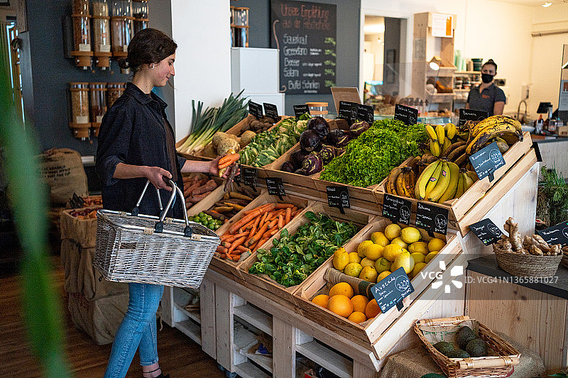 年轻女人在有机食品店购物图片素材