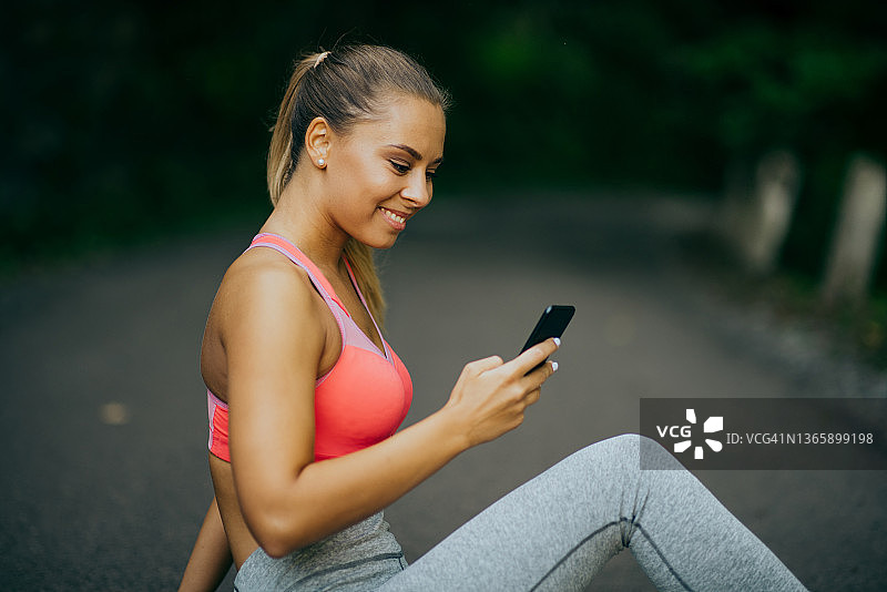 使用手机的年轻运动型女人图片素材