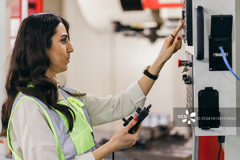 女操作员正在对数控机床进行编程图片素材