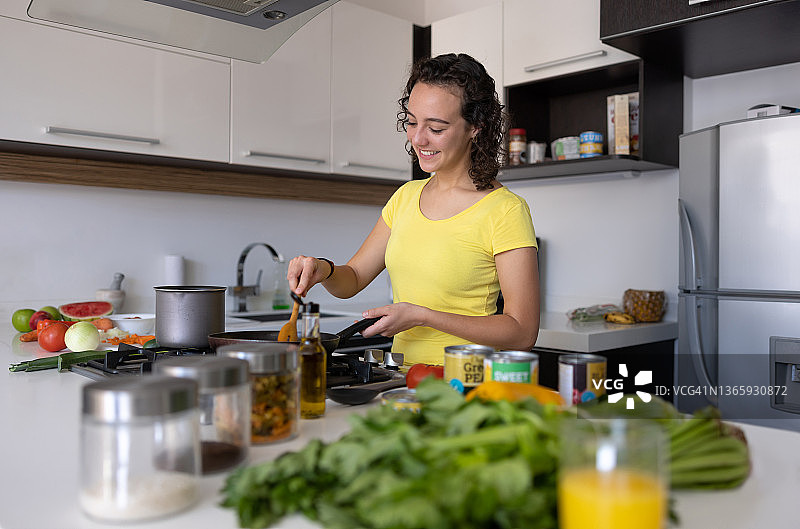 年轻女人在家做晚餐图片素材