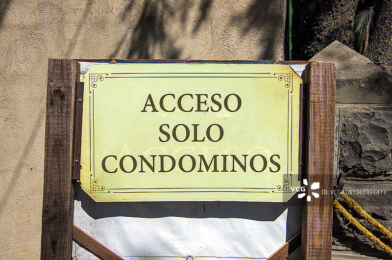 公寓大楼车道上的西班牙语标志，上面写着“Acceso solo condominos”[仅限公寓访问]图片素材
