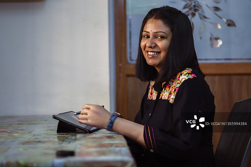 使用手写笔平板电脑的年轻女性图片素材