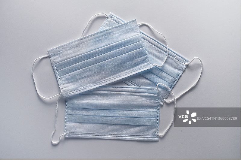 用于预防病毒的医用外科口罩。空气污染、肺炎爆发、预防冠状病毒流行病和生物污染风险的概念。白色桌子背景上的防护口罩。图片素材