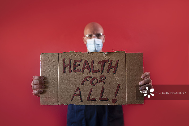 医生举着一个写着“人人享有健康”的纸板图片素材