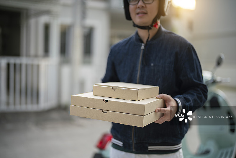 男人送餐，拿着披萨盒图片素材