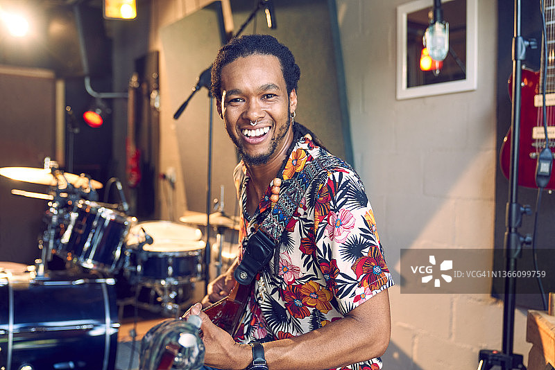 快乐的男音乐家在录音室弹吉他图片素材