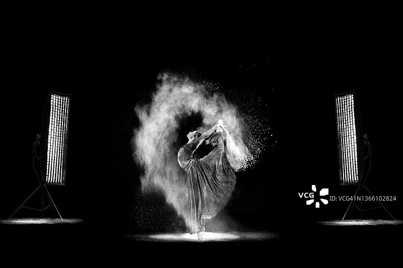 在黑色背景上撒粉跳舞图片素材