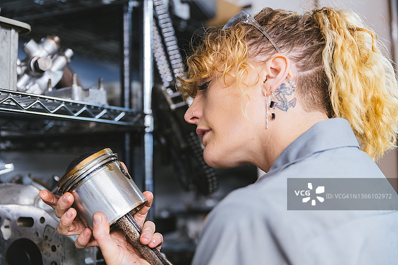 女汽车修理工检查活塞图片素材