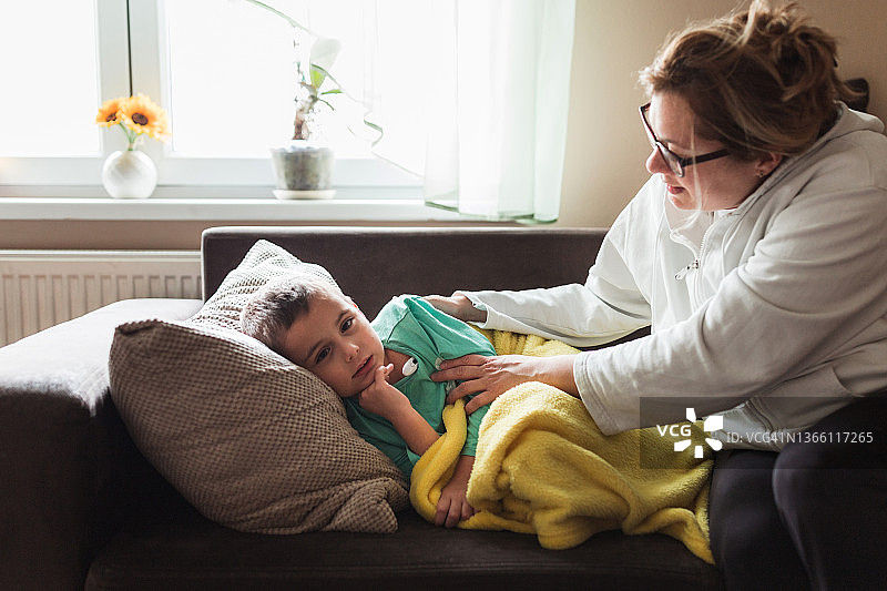 母亲给儿子量体温并拥抱图片素材