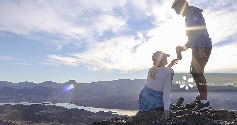 徒步情侣在阳光明媚的山脊上放松图片素材