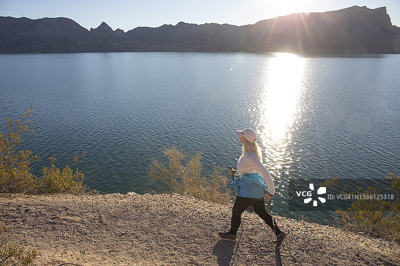 女人在阳光明媚的山脊上徒步旅行图片素材