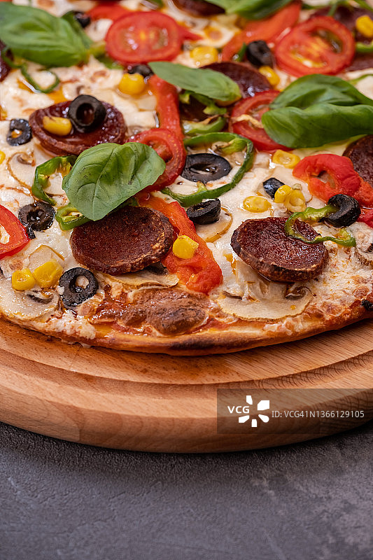 带萨拉米香肠、罗勒和红辣椒的意式香肠披萨图片素材