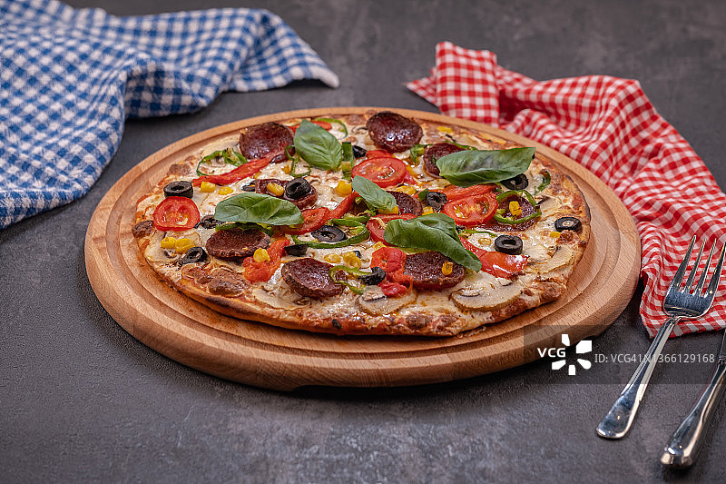 带萨拉米香肠、罗勒和红辣椒的意式香肠披萨图片素材