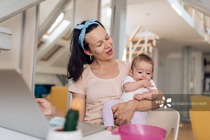 母亲和宝宝在家里的办公室工作图片素材