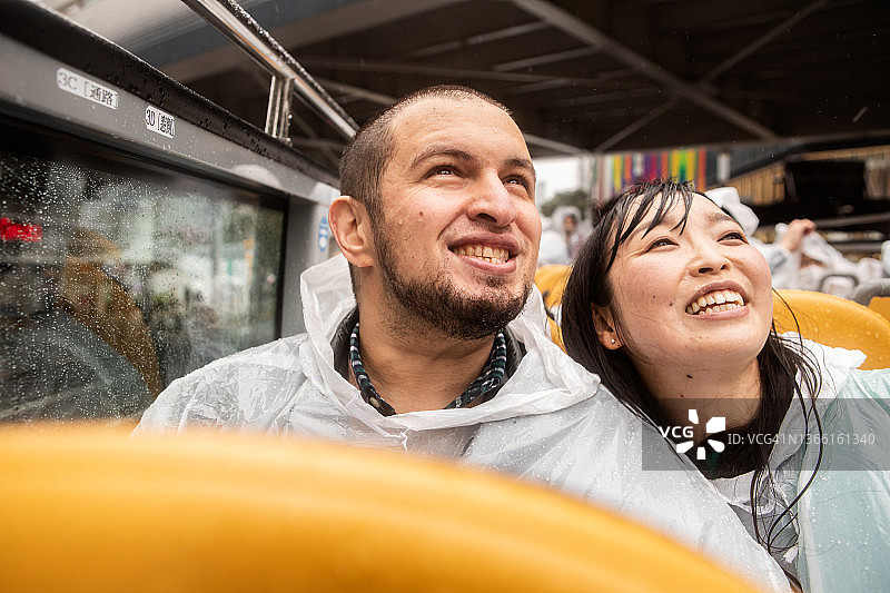 情侣冒雨乘坐敞篷巴士观光图片素材