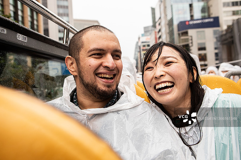情侣冒雨乘坐敞篷巴士观光图片素材