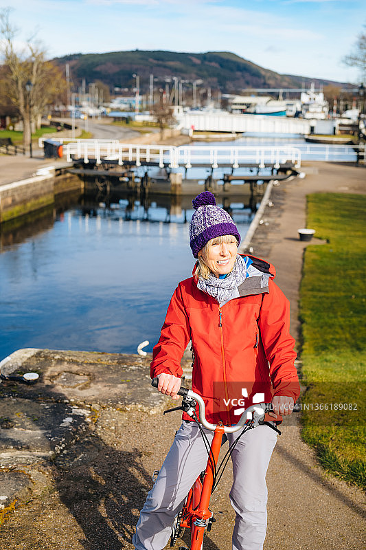 女人在苏格兰因弗内斯喀里多尼亚运河旁骑自行车图片素材