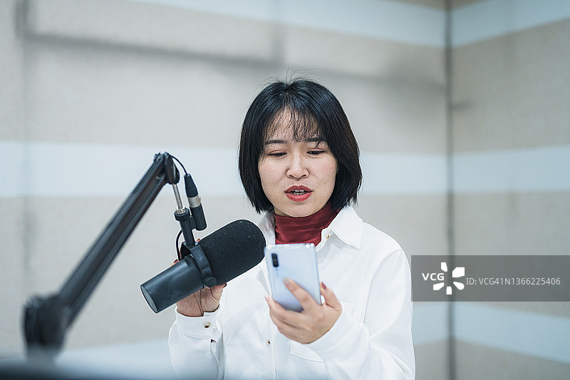 年轻电台女主持人正在播音。图片素材