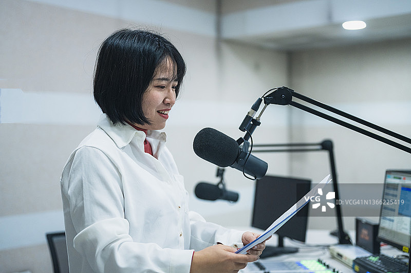 年轻电台女主持人正在播音。图片素材