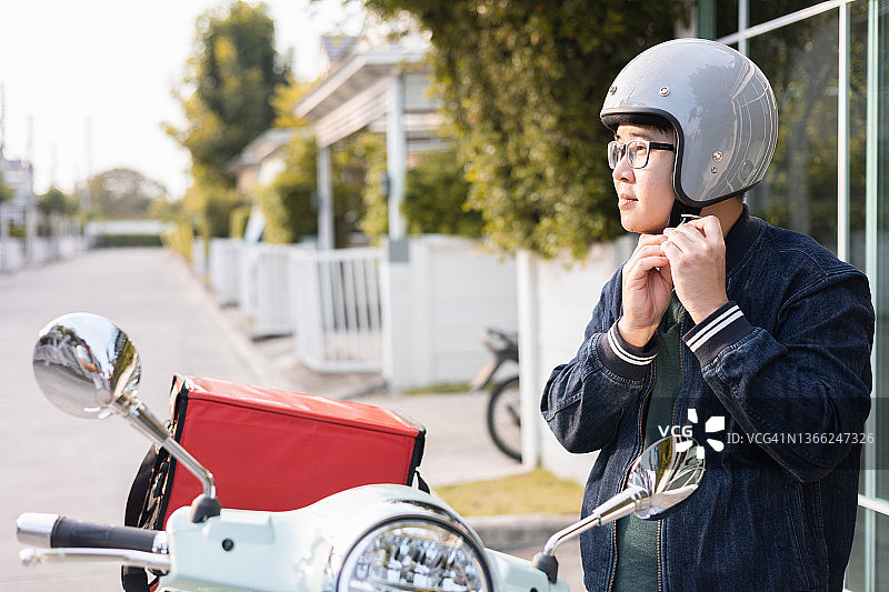 城市街道上戴安全帽的外卖员图片素材