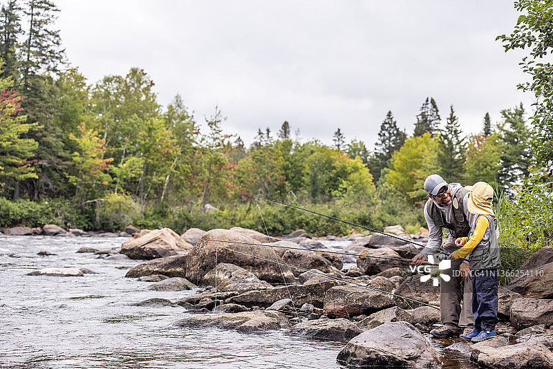 在魁北克河里钓鱼的可爱红发男孩和父亲图片素材