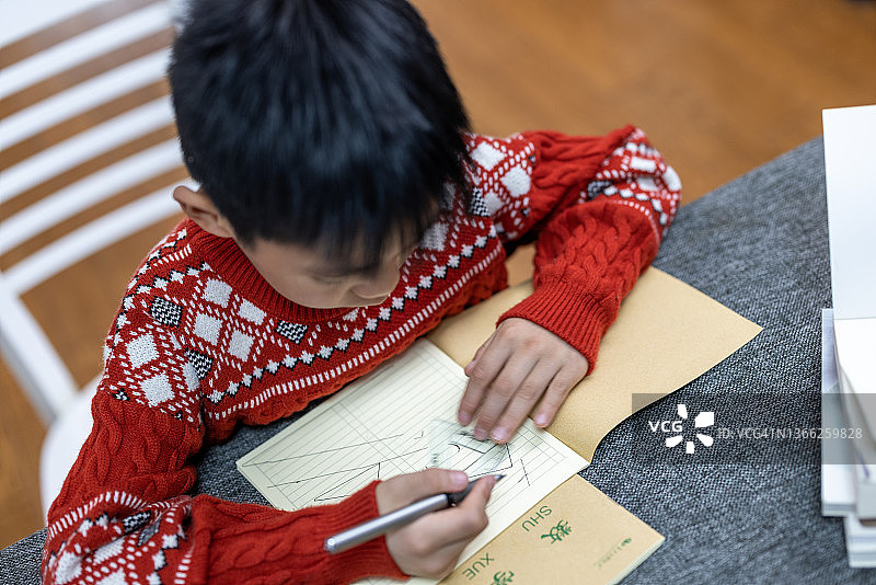 小男孩在餐桌上做作业图片素材