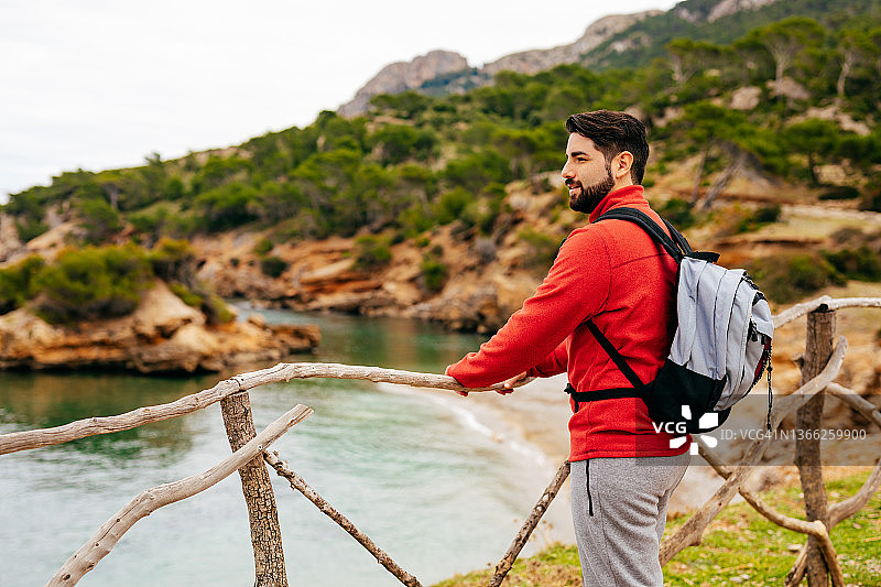 在马略卡岛北海岸的木栅栏旁眺望大海的徒步旅行者图片素材