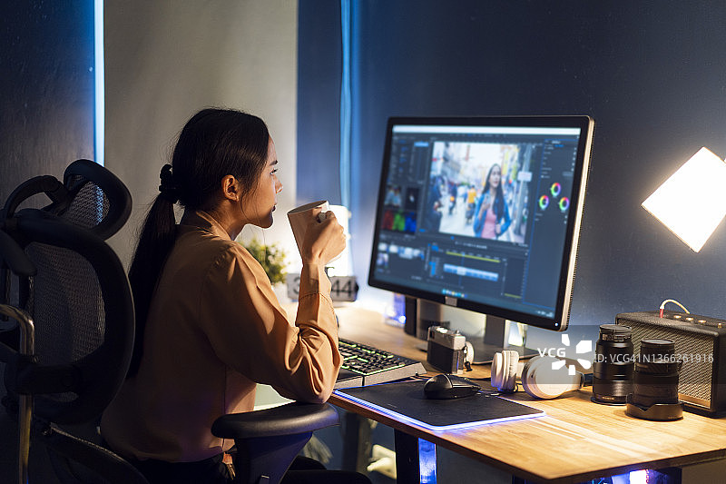 年轻女时装摄影师在电脑上处理时尚照片图片素材