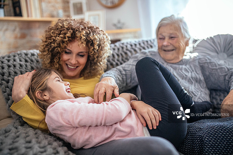 坐在沙发上快乐的三代同堂家庭图片素材