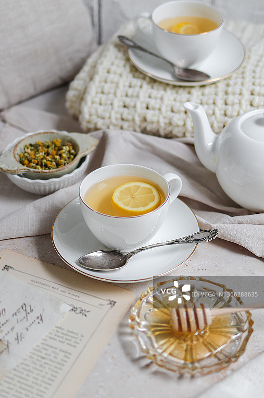 舒适的乡村厨房里放着新鲜洋甘菊蜂蜜柠檬姜茶图片素材