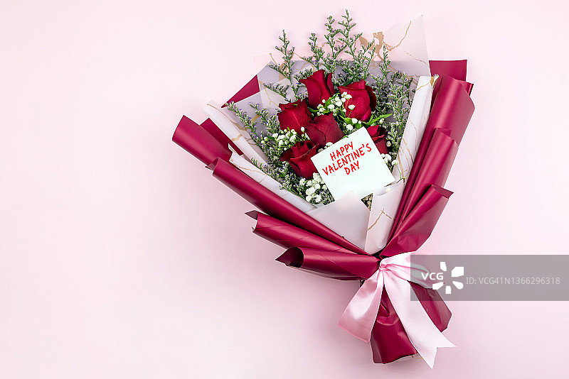 粉色背景上的情人节红色玫瑰花束图片素材