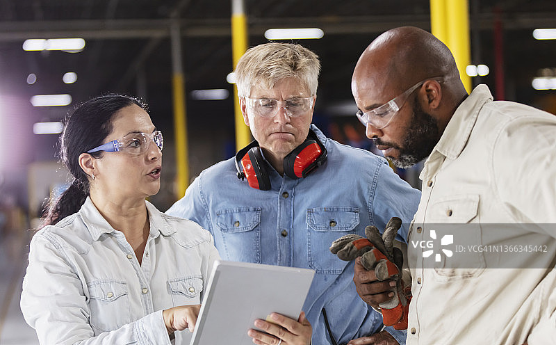 在塑料工厂会面的多种族工人图片素材