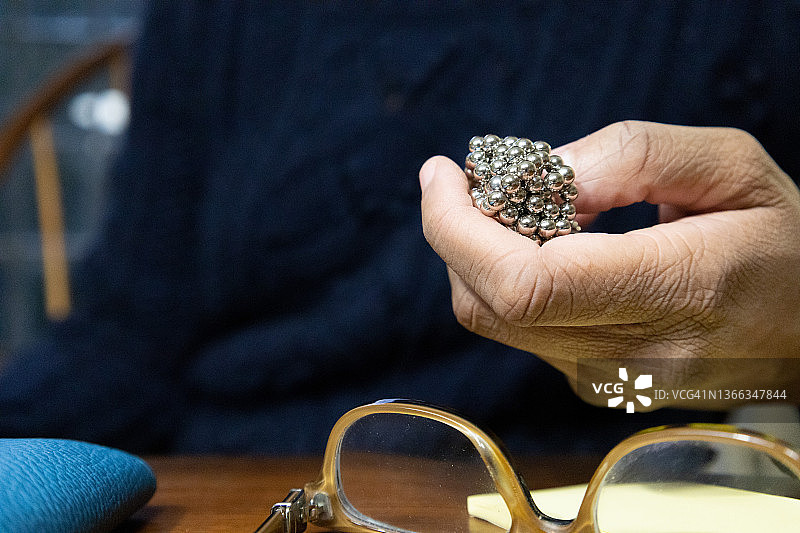 在家办公桌前工作的黑人女性拿着磁性玩具图片素材