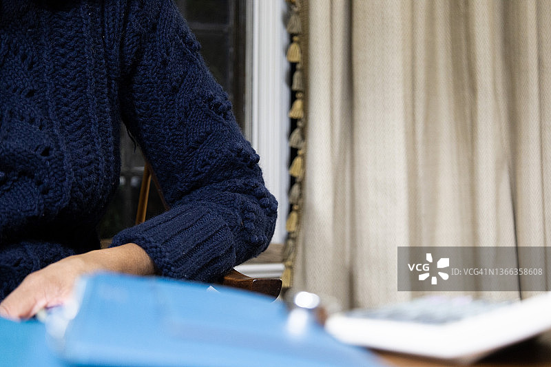 黑人女人在家使用计算器图片素材