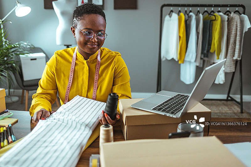 时装设计师在工作室使用笔记本电脑图片素材