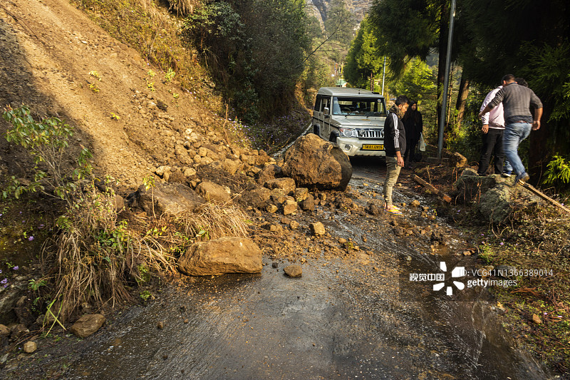 拉雄村的滑坡和被困的汽车，当地居民试图清理道路图片素材