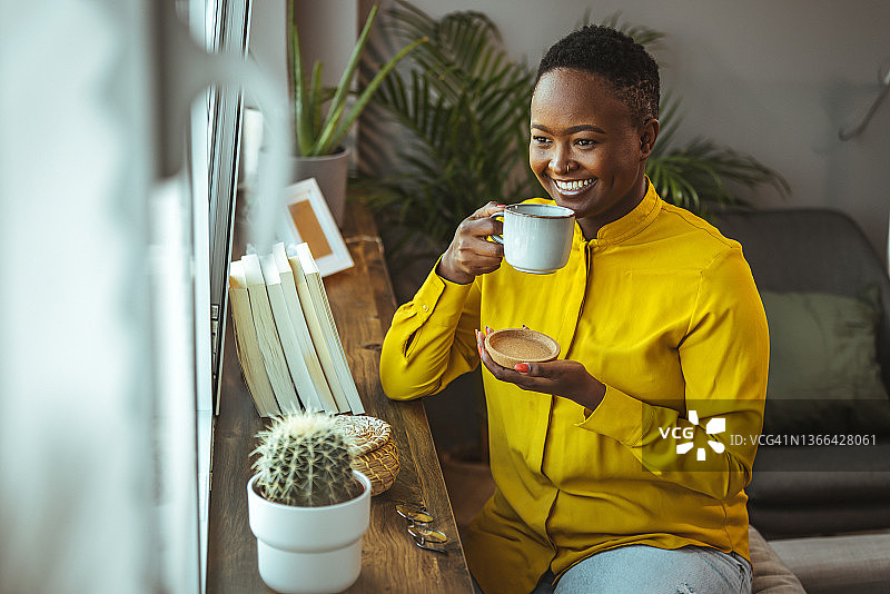 女人在家喝咖啡并看向窗外图片素材