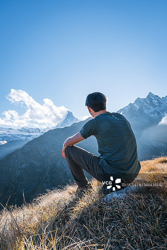 徒步旅行者在阳光明媚的草山脊上放松图片素材