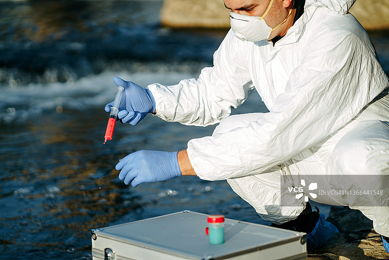 生态学家从河中取水样特写：检查污染程度图片素材