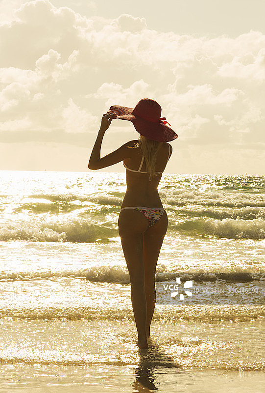 日落时分在海滩上的女人图片素材