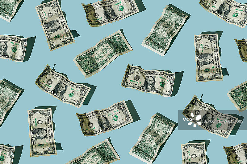 蓝色背景下的皱巴巴的美元钞票图片素材