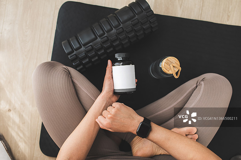 女人手中拿着一瓶膳食补充剂或维生素图片素材