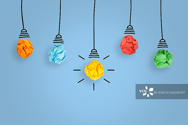 蓝色背景上的创意灯泡纸团图片素材