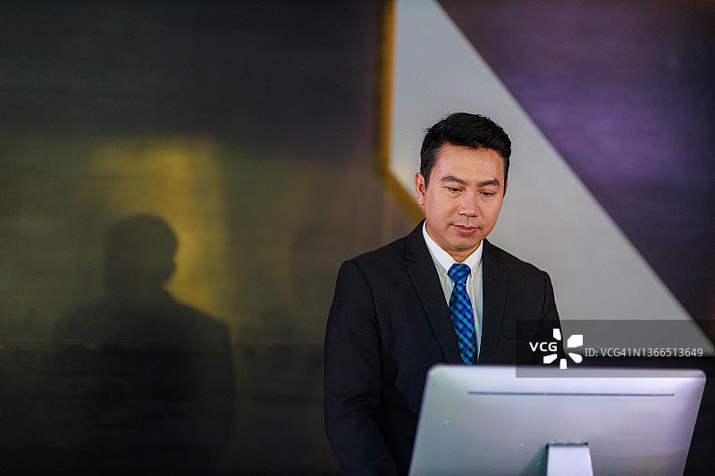 男酒店经理站在大堂接待柜台前图片素材