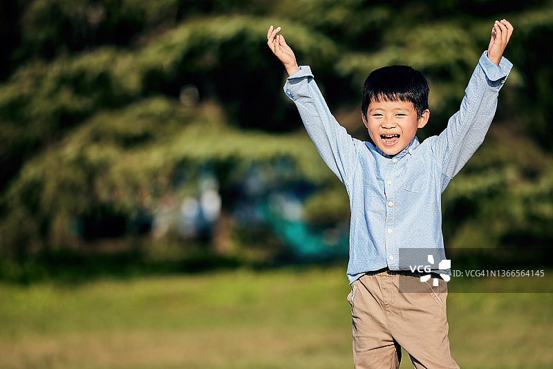 快乐的孩子在户外举手图片素材