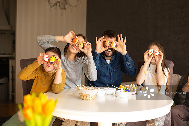 父母和孩子们拿着复活节彩蛋，在眼前嬉戏图片素材