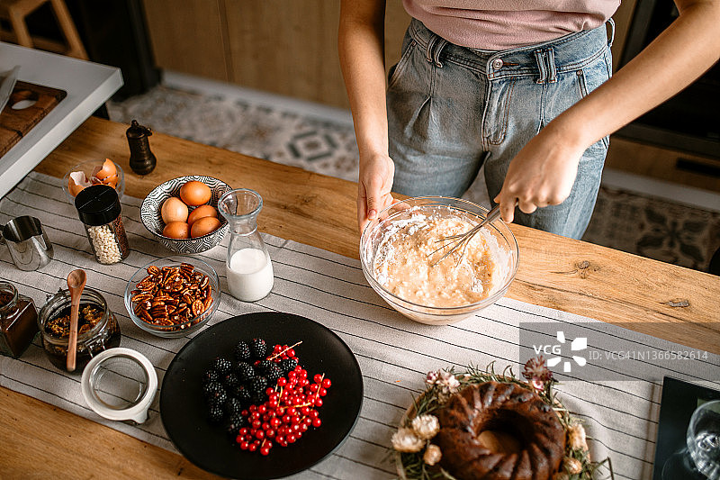 在厨房里打鸡蛋制作完美蛋糕的女人图片素材