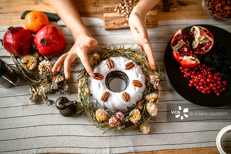 女人用山核桃碎装饰蛋糕图片素材