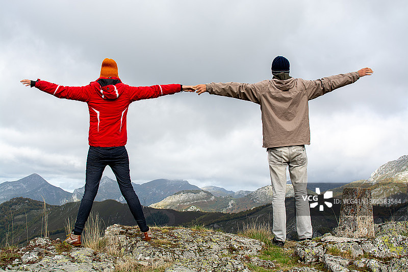 大自然中手牵着手、张开双臂的两人背影图片素材