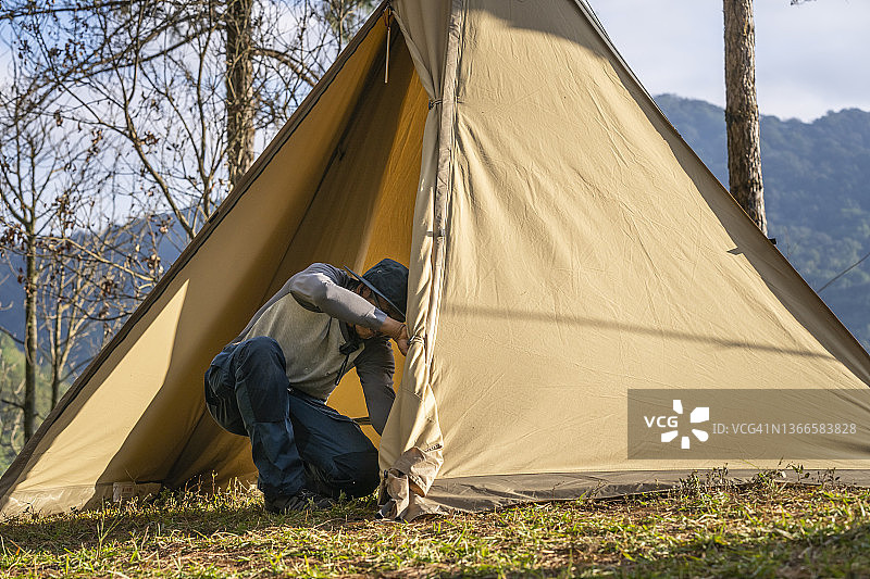 男人在森林里搭帐篷露营图片素材